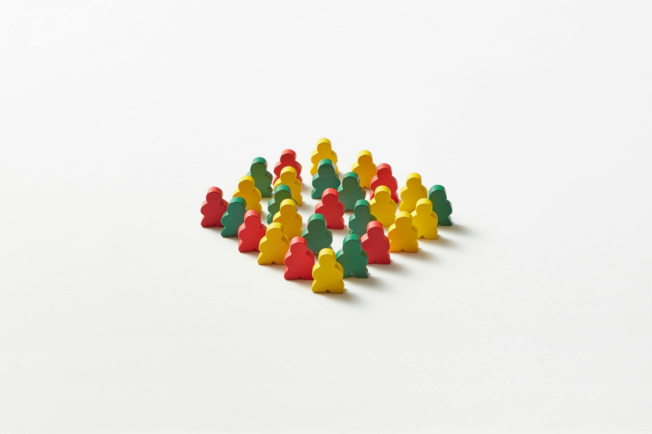 Cluster of multicolored game pawns arranged on a plain white background.
